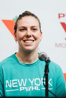 Jaime Bourbonnais wearing a bright New York PWHL t-shirt and smiling while being interviewed