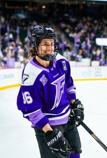 Michela Cava in a purple Minnesota Frost jersey smiling at the camera.