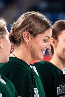 Sam Isbell (PWHL Boston) smiling with her teammates and lined up for the national anthem