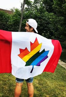 Jamie Lee Rattray holding a pride Canadian flag behind her back