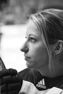 Close-up photo of Savannah Harmon on the bench listening to the pre-game anthem