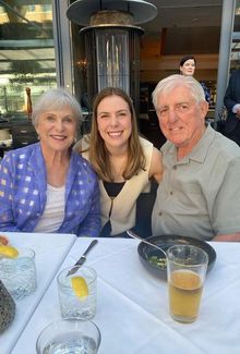 Jamie Bourbonnais posing for a photo at a restaurant with an older couple