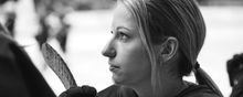 Close-up photo of Savannah Harmon on the bench listening to the pre-game anthem