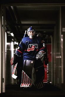 Nicole Hensley in her hockey gear and team USA uniform walking down the hallway with dramatic lighting