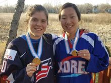 Hannah Brandt and her sister Marissa posing for a photograph with their gold medals