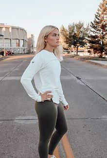 Emma Soderberg in olive leggings standing in the middle of the street.