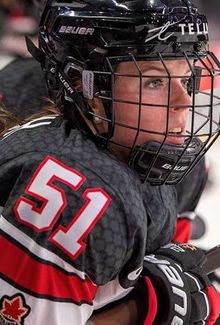 Victoria Bach (Team Canada) intently observes the hockey game from the bench