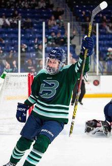 Susanna Tapani raising her stick while celebrating scoring a goal.