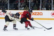 PWHL Montreal forward Laura Stacey fights for a puck with PWHL Ottawa defender Savannah Harmon