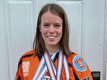 Victoria Bach dons an Orange Jersey Project hockey jersey, an initiative she is involved with, while showing off her medals.